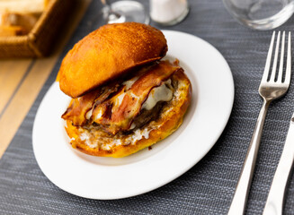 Tasty hamburger with cutlet, cheese and bacon closeup