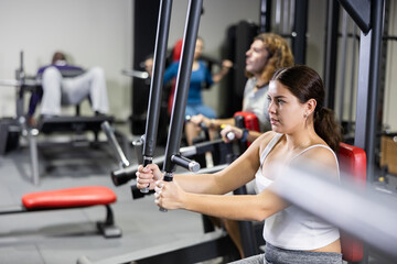 Caucasian woman doing exercises on chest fly machine in gym