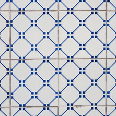 Naklejka premium Fragment of building wall with colorful ceramic tiles. Azulejos, close up. Traditional ornate Portuguese architecture. Abstract background, textured ornate pattern for design or backdrop.