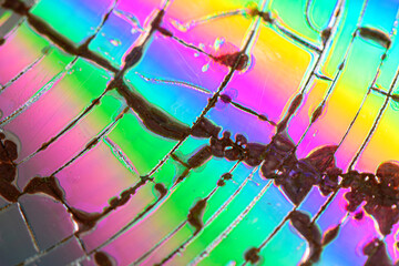 Abstract background of cracked surface with an iridescent pattern. Texture of cracked CD surface. Network of lines, vibrant colors. Light waves reflecting off thin layers. Design project concept