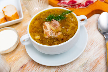 Soup of cabbage with boiled vegetables and pork broth, served in plate. High quality photo