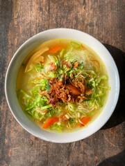 Chicken soto in a bowl on a wooden background
