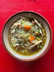 Chicken soto in a bowl on a wooden background