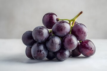 A cluster of plump purple grapes with a green stem