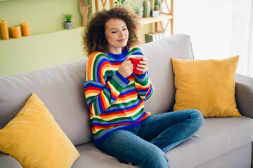 Obraz premium Portrait of pretty young woman sit sofa smell coffee wear sweater modern interior flat indoors
