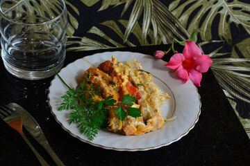 A close-up shot of a gourmet plate featuring a variety of savory delicacies, including cheese, olives, and a mix of grilled meats, garnished with herbs. Selective focus on the dish.