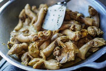 Close-up of Indonesian chicken necks simmering in a wok. Rich, flavorful dish. Delicious Indonesian Chicken Necks Cooking in Wok
