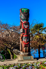 A tall wooden pole with carvings of animals on it