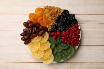 Mix of different dried fruits on wooden table, top view