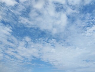 clear blue sky with a few clouds. The sky is very bright and the clouds are scattered throughout