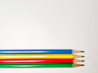 blue, yellow, red, and green pencils on a white background