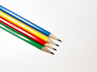blue, yellow, red, and green pencils on a white background