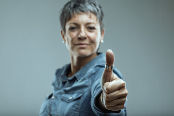 Mature woman showing thumbs up sign expressing approval