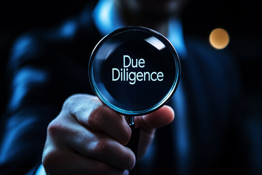Due diligence concept, Businessman holding a magnifying glass with due diligence icon on virtual screen.