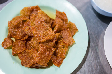 Sliced sheets of dried and crispy pork on dish. Sweet pork sheet