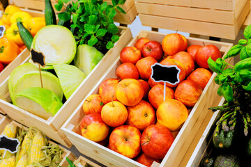 Freshly harvested apples, vegetables are neatly displayed in wooden crates at bustling local farmers market
