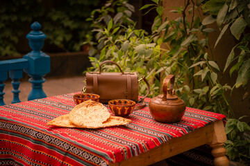 The table outside on a terrace with copper teapot and Uighur bread in Kashgar Old Town