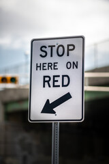 Stop Here on Red Traffic Sign Close-Up Against a Cloudy Sky