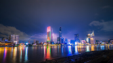 view of Bitexco and IFC One Tower, buildings, roads and Saigon river in Ho Chi Minh city - Laser and lighting show displayed. Travel and landscape concept