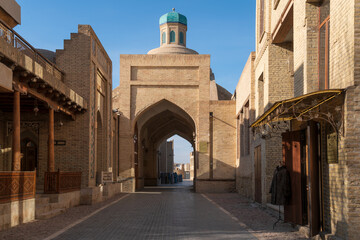 Obraz premium View of Bahauddin Naqshbandi Street and the building of the traditional covered bazaar Toqi Sarrofon in the historical center of the city on a sunny day, Bukhara, Uzbekistan