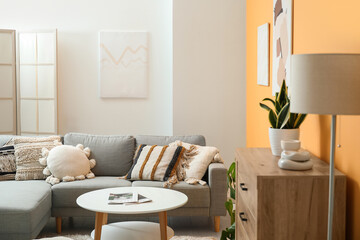 Comfortable sofa, picture and coffee table in interior of living room