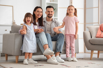 Beautiful happy family sitting on sofa at home