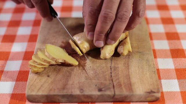 Slicing ginger root to prepare tea