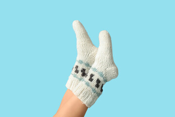 Legs of young woman in knitted socks on blue background