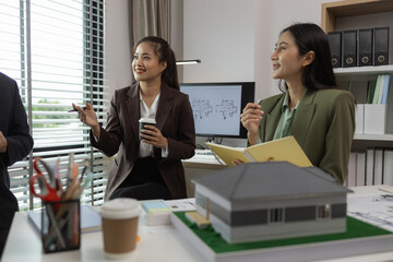 Architects work with engineers and contractors in the office to check the accuracy of the first draft plan, blueprint on the desk, three architects are working together in the workplace