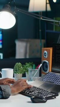 Vertical video AI expert writes code on laptop in apartment office using Java programming languages. Artificial intelligence programmer remotely working on fixing database errors while working from
