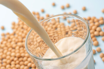 ガラスコップに豆乳を注ぎ込む瞬間と大豆