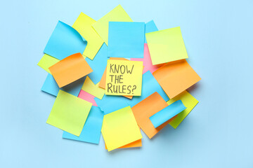 Sticky notes with text KNOW THE RULES? on blue background