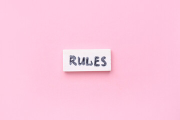 Block with word RULES on pink background