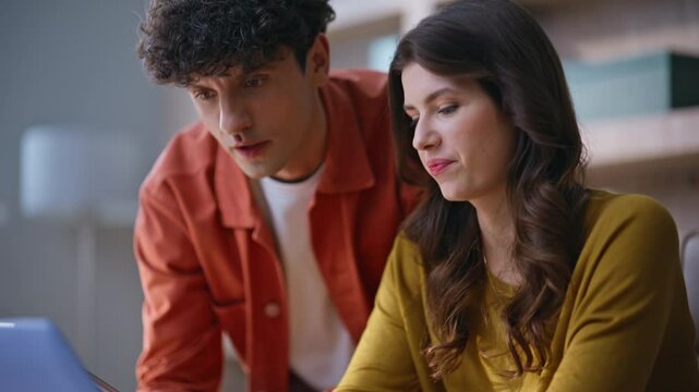 Inspired professionals talking project looking laptop at workplace closeup.