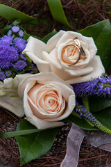 A beautiful floral bouquet featuring stunning roses and intertwined wedding rings, ideal for romantic occasions