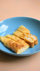 roll omelette stuffed with chesse and rice on blue plate, delicious food in the morning