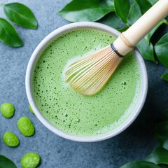 Oversized Matcha Latte Being Stirred with Bamboo Whisk and Garnish