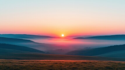 Fototapeta premium A stunning sunrise casts warm hues over misty hills, creating a serene landscape that evokes peace and tranquility.