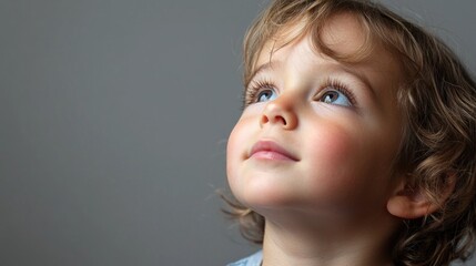 Child with a hopeful expression, perhaps dreaming or looking at something with wonder