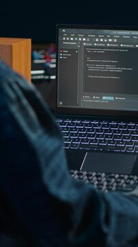 Vertical video Software developer writes code on laptop screen while in apartment office using Java programming languages. Programmer remotely working on fixing database errors while working from home