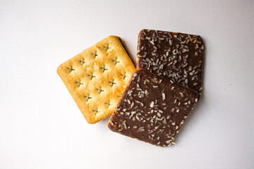 Chocolate biscuits with coconut sprinkles on white background