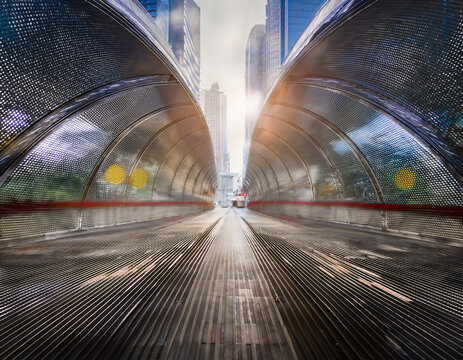 地下鉄のトンネルや高層ビルの影の中で光が広がり、都市内部の無限の可能性を象徴する　ビルの光と影が自己探求の舞台を映し出すアブストラクトで滑らかな背景イメージ