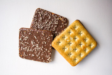 Chocolate biscuits with coconut sprinkles on white background