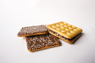 Sandwich biscuits with chocolate filling and coconut sprinkles on white background