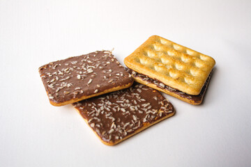 Sandwich biscuits with chocolate filling and coconut sprinkles on white background