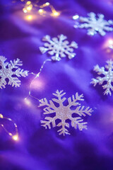 Christmas vertical background with glowing snowflakes on purple canvas