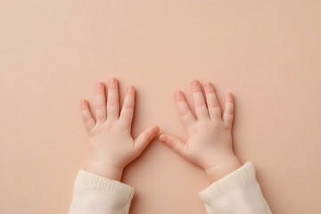 Small child hands on beige background top view. Skin care, family, playing and education template concept.
