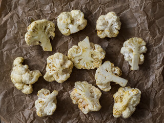 Inflorescences of raw cauliflower with spices and olive oil on a baking sheet