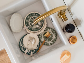 Vintage plates, a brush with natural bristles, soap in a ceramic sink, top view. Household concept