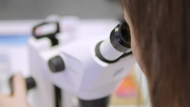 A Research Scientist Conducting Experiments Using a Microscope in a Laboratory Setting
